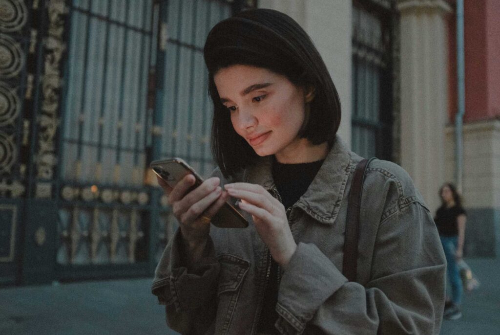 Mujer caminando por las calles con su celular