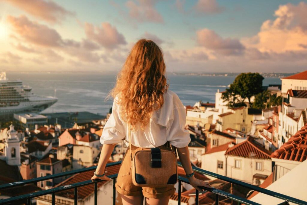 Mujer en el balcón de su casa viendo hacia el mar