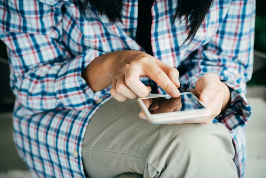 Mujer sentada con celular en mano