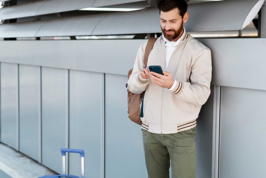 Hombre texteando en su llegada al aeropuerto