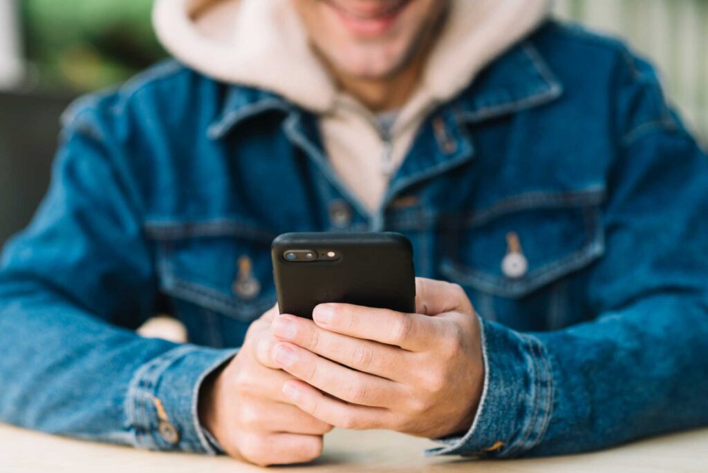 Hombre revisa su celular y se pone feliz