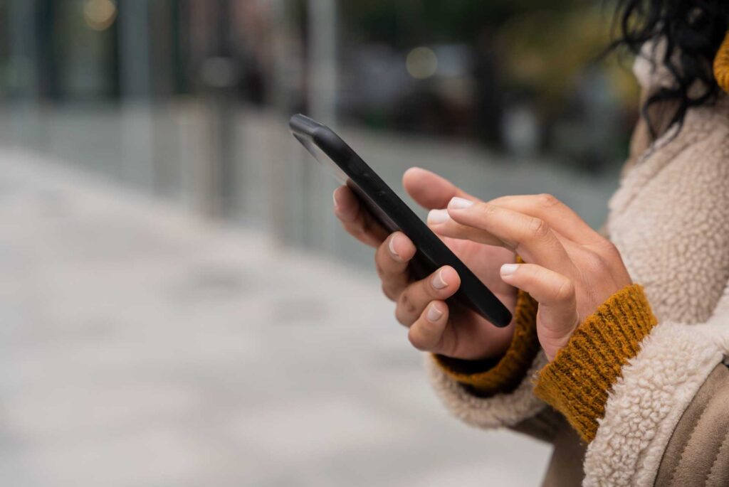 Mujer usando un celular en la calle