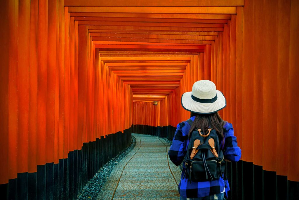 Mujer visita el lugar turístico Santuario de Fushimi Inari en Asia