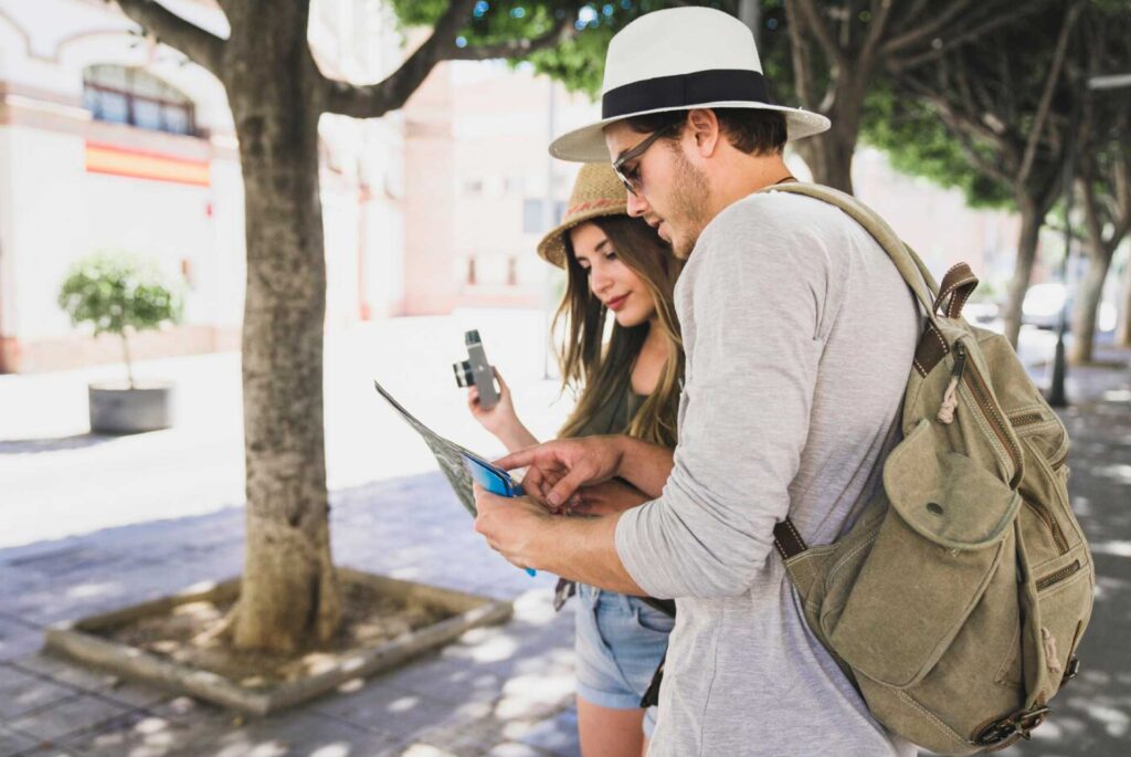 Una pareja de turistas busca en un mapa lugar para visitar