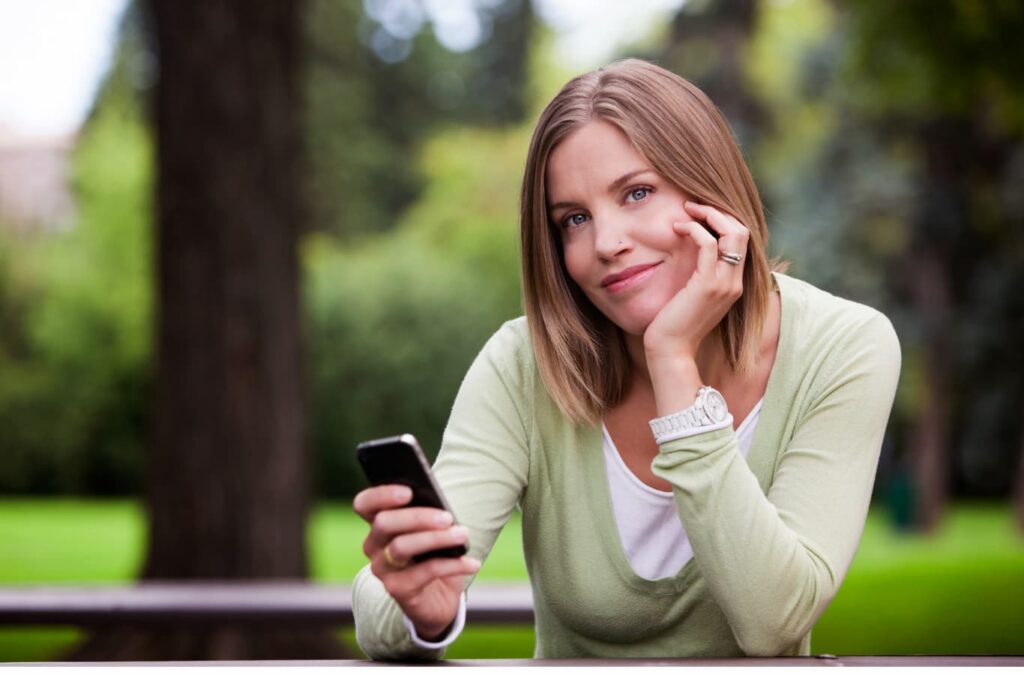 Mujer sosteniendo un teléfono celular en la mano